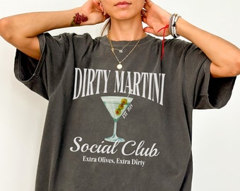 May include: A dark gray oversized t-shirt with a graphic print of a martini glass with olives and the text "Dirty Martini Social Club Est 1974 Extra Olives, Extra Dirty."