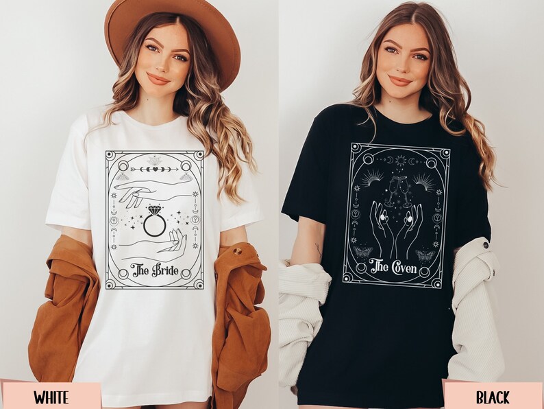 May include: Two t-shirts with a tarot card design. The white t-shirt has a design of two hands with a ring, and the text "The Bride". The black t-shirt has a design of two hands with a chalice, and the text "The Coven".