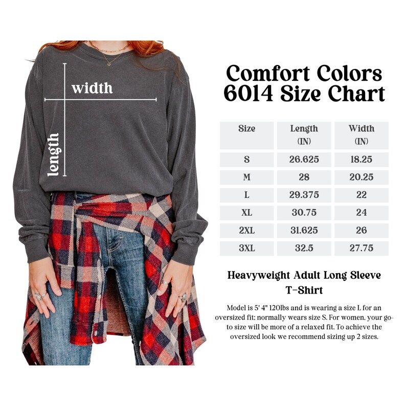 May include: A dark gray heavyweight adult long sleeve t-shirt. The image includes a size chart for Comfort Colors 6014, with measurements in inches. The model is wearing a size L for an oversized fit. The shirt is shown with jeans and a plaid shirt.