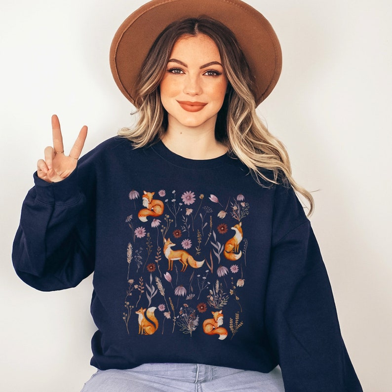 May include: A navy blue sweatshirt with a pattern of orange foxes and purple flowers.