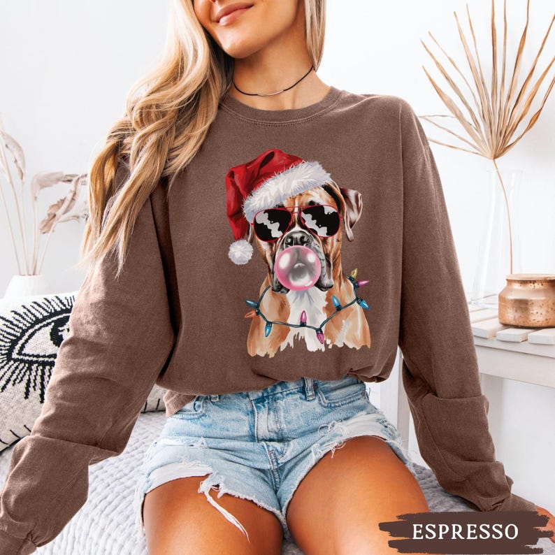 May include: Espresso-colored sweatshirt featuring a Boxer dog wearing sunglasses and a Santa hat, blowing a bubblegum bubble. The dog is adorned with Christmas lights. The word "ESPRESSO" is printed at the bottom of the image.