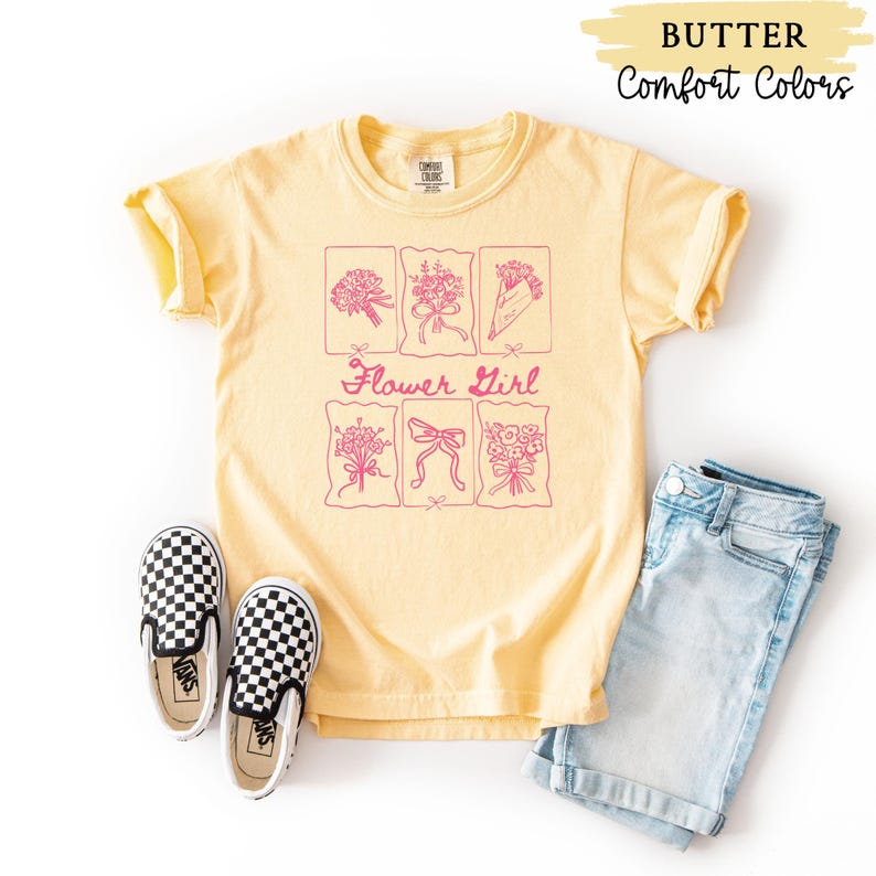 May include: Butter yellow t-shirt with a pink floral design and the words "Flower Girl". The shirt is paired with blue denim shorts and black and white checkered slip-on shoes. The words "Butter" and "Comfort Colors" are in the top right corner.