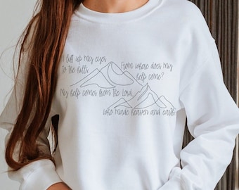 May include: White sweatshirt with a black mountain range graphic and the text "I lift up my eyes to the hills. From where does my help come? My help comes from the Lord, who made heaven and earth."