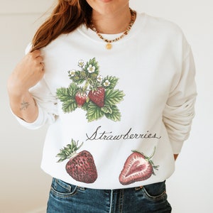 May include: White sweatshirt with a graphic of strawberries and the text "Strawberries".