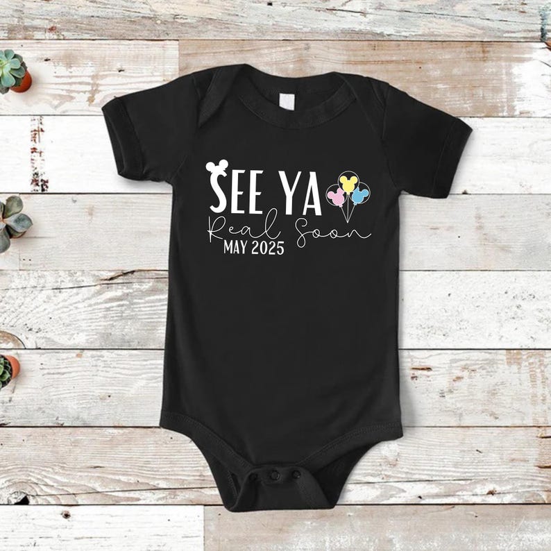May include: Black baby onesie with white text that reads "See Ya Real Soon MAY 2025" with a Mickey Mouse head and three Mickey Mouse head balloons in pink, blue, and yellow.