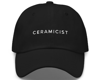 Może przedstawiać: Czarna czapka z daszkiem z haftem "CERAMICIST" w kolorze białym z przodu.