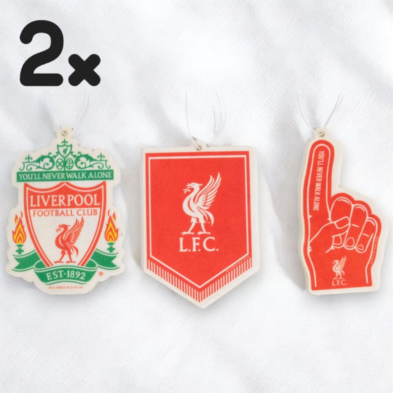 May include: Two Liverpool Football Club car air fresheners. One is a red shield with the team's crest and the words "L.F.C." and "You'll Never Walk Alone". The other is a red foam hand with the team's crest and the words "L.F.C." and "You'll Never Walk Alone".