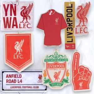 May include: A set of eight car air fresheners featuring the Liverpool Football Club logo. The air fresheners are in various shapes and sizes, including a jersey, a crest, and a finger.