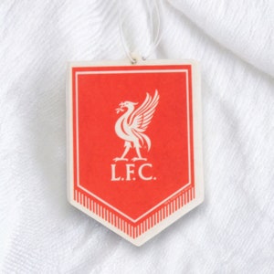 May include: Red and white car air freshener shaped like a shield with a white bird logo and the text "L.F.C."