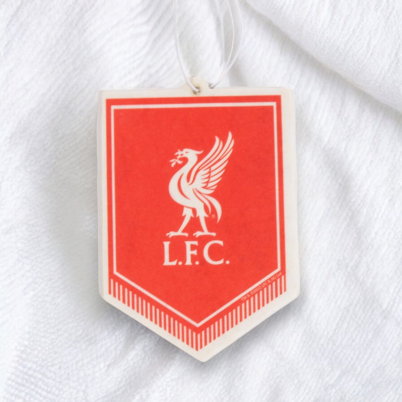 May include: Red and white car air freshener shaped like a shield with a white bird logo and the text "L.F.C."