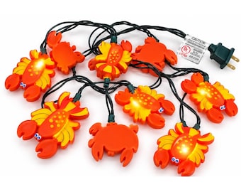 Può includere: Una catena luminosa con coperture a forma di granchio arancioni e gialle. I granchi hanno piccoli occhi blu e bianchi e alcuni sono illuminati dall'interno. Il set include un cavo elettrico nero e una spina standard.