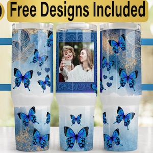 May include: A set of three insulated tumblers with blue butterfly designs and a blue handle. One tumbler features a photo of two women. The text "10 Free Designs Included" is at the top.