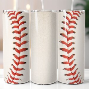 Puede incluir: Un vaso cil&iacute;ndrico con una superficie blanca y un patr&oacute;n repetitivo de costuras de b&eacute;isbol rojas que envuelve el exterior. El vaso incluye una tapa transparente y una pajita fina y recta que sobresale del centro de la parte superior.