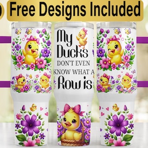 May include: White tumbler with a purple lid and handle. The tumbler has a design of yellow ducklings with flowers and the text "My Ducks Don't Even Know What A Row Is".
