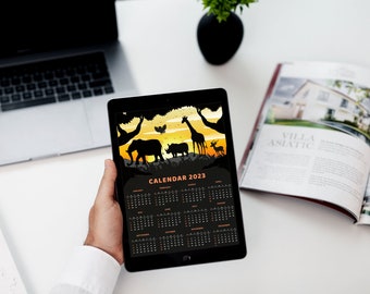 May include: A black tablet displaying a 2023 calendar with a sunset scene featuring silhouettes of animals, including an elephant, rhinoceros, giraffe, and antelope. The text "CALENDAR 2023" is at the top of the calendar.