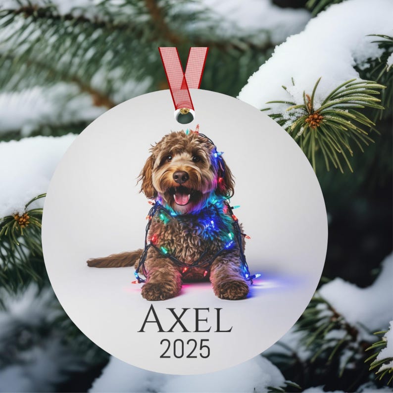 Round Christmas ornament with a labradoodle wrapped in colorful Christmas lights.  Axel and 2025 are at the bottom.  Name and year can be personalized.