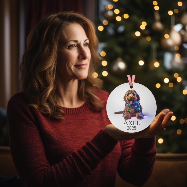 Round Christmas ornament with a labradoodle wrapped in colorful Christmas lights.  Axel and 2025 are at the bottom.  Name and year can be personalized.
