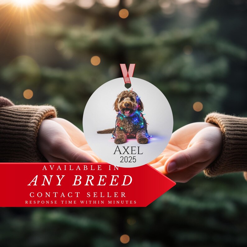 Ornament is being held by two hands.  Red banner at bottom says available in any breed.  Contact seller.
