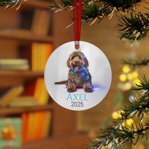 Round Christmas ornament with a labradoodle wrapped in colorful Christmas lights.  Axel and 2024 are at the bottom.  Name and year can be personalized.