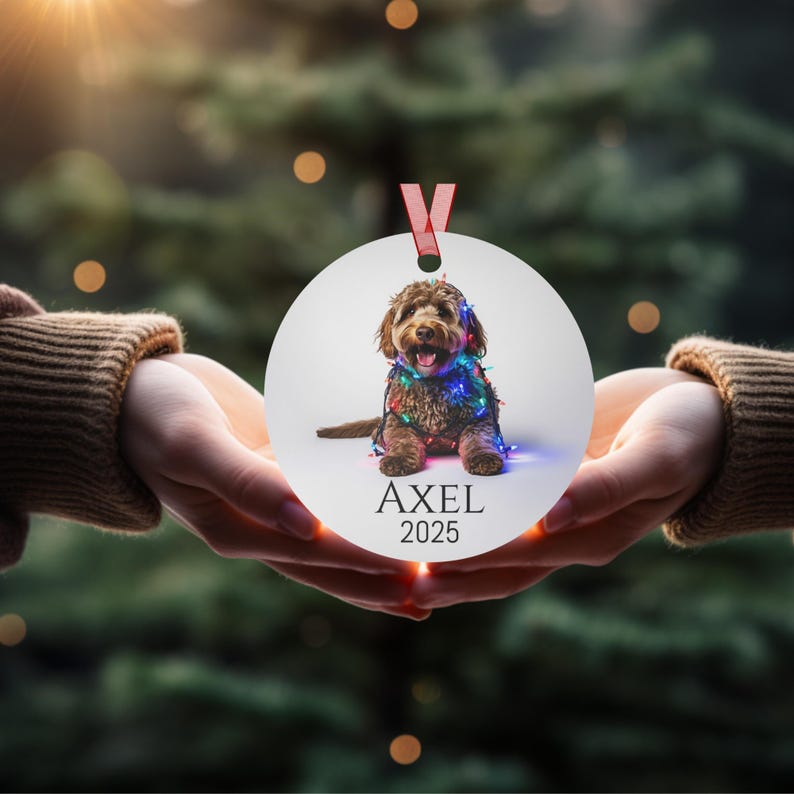 Round Christmas ornament with a labradoodle wrapped in colorful Christmas lights.  Axel and 2025 are at the bottom.  Name and year can be personalized.
