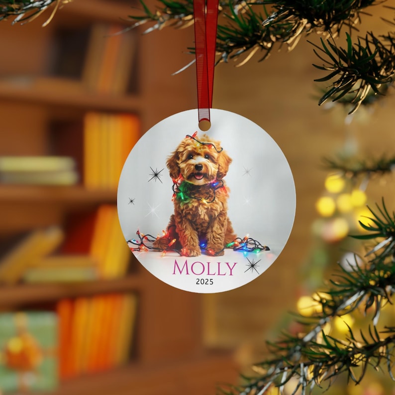 Round aluminum Christmas ornament.  The ornament has a Cavapoo wrapped in colorful Christmas lights.  At the bottom is Molly 2025.