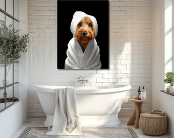 May include: A framed canvas print featuring a dog wearing a white towel on its head and a white robe against a black background. The dog has brown fur and is looking directly at the viewer. The image is displayed in a bathroom setting.