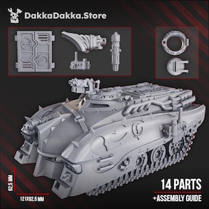 Op de afbeelding: Een grijze, niet-gemonteerde modeltank met meerdere onderdelen, waaronder een hoofdgedeelte, torentjes en extra componenten. De tank meet 12,1 x 9,25 cm en is 6,25 cm hoog. De afbeelding bevat de tekst "14 ONDERDELEN + MONTAGEGIDS" en de winkelnaam "DakkaDakka.Store".