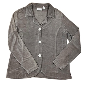 May include: A taupe-colored button-down jacket with a notched collar and long sleeves. The jacket has three white buttons down the front and a curved hemline. The brand name "Chico's" is visible on the label.