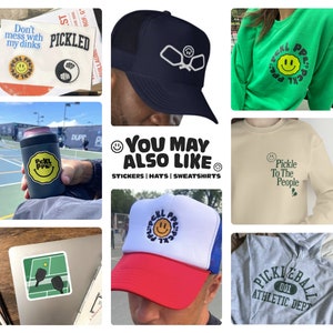 Puede incluir: Un collage de im&aacute;genes con mercanc&iacute;a tem&aacute;tica de pickleball, incluyendo calcoman&iacute;as, sombreros y sudaderas. El texto "You May Also Like" se muestra en un c&iacute;rculo con una carita sonriente. El texto "Stickers | Hats | Sweatshirts" se muestra debajo del c&iacute;rculo.