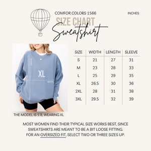 May include: A light blue sweatshirt with a size chart and the text "Sweatshirt." The chart lists measurements in inches for sizes S to 3XL. The model is 5'8" and wearing an XL. The text advises selecting two or three sizes up for an oversized fit.