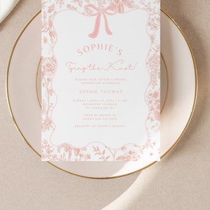 Peut inclure: Une invitation de f&ecirc;te pr&eacute;nuptiale rose et blanche &agrave; fleurs avec un n&oelig;ud rose et le texte "Sophie's Tying the Knot!"  Veuillez nous rejoindre pour une f&ecirc;te pr&eacute;nuptiale en l'honneur de Sophie Thomas. Dimanche 17 avril 20XX | 11h00. Roundtop Terrace, 157 Ridge Rd, NY. RSVP avant le 12 mars, Sarah 646-523-5555. Liste de mariage chez Crate & Barrel.