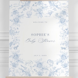 May include: A blue and white baby shower welcome sign with a floral design and the text "Welcome to Sophie's Baby Shower July 3, 20XX".