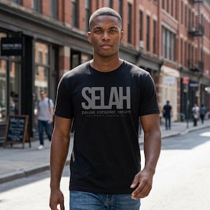 Puede incluir: Camiseta negra de cuello redondo con la palabra "SELAH" en letras grises. Debajo, las palabras "pause, consider, return" están escritas en letra más pequeña. La camiseta es de faithwell supply co.
