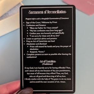 May include: A rectangular black card with white text detailing the Sacrament of Reconciliation and the Act of Contrition. The card features a double-line border and lists steps for confession, including the Sign of the Cross and penance.
