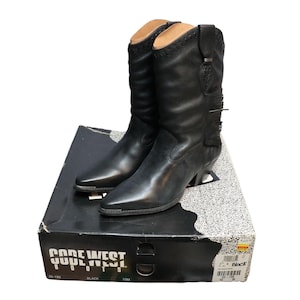 May include: Black leather Code West cowboy boots with pointed toes and fringe detail. The boots are size 10M and are displayed on top of their original black box.