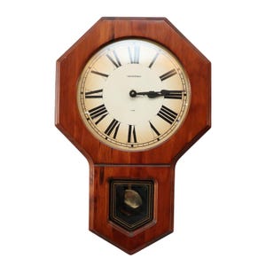 May include: A wooden pendulum clock with a white face and black Roman numeral hour markers. The clock has a dark wood frame and a pendulum.
