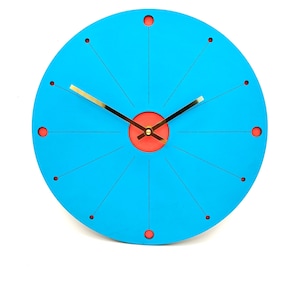 May include: A circular wall clock with a bright cyan face featuring thin black radial lines and small red circular markers at each hour position. The center has a red circular accent and two thin gold-colored metal clock hands.