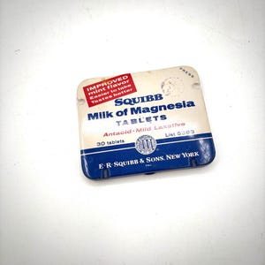 May include: Vintage SQUIBB Milk of Magnesia tablets package. The package is white and blue with the text "SQUIBB Milk of Magnesia Tablets" and "Antacid-Mild Laxative". It also has the text "Improved mint flavor, easier to take, tastes better".
