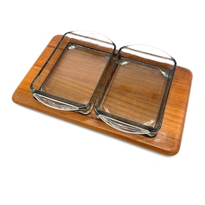 Könnte beinhalten: Ein Holztablett mit zwei klaren Glasschalen. Das Tablett ist aus hellbraunem Holz und hat eine rechteckige Form. Die Schalen sind quadratisch und haben abgerundete Ecken.
