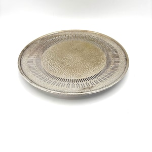 May include: A silver circular tray with a hammered texture and a decorative border of small holes.