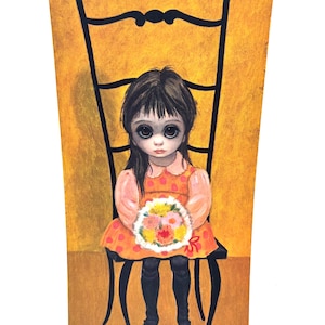 May include: A vintage print of a young girl with large eyes, seated on a black chair, holding a bouquet of flowers. The girl wears a polka-dot dress and black boots. The background is yellow. The print is signed "Keane 1962".