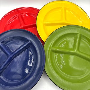 Peut inclure: Quatre assiettes divisées colorées en rouge, jaune, bleu et vert. Chaque assiette comporte trois compartiments, idéales pour le contrôle des portions. Les assiettes ont une finition brillante et sont disposées en gros plan, mettant en valeur leurs couleurs vives.