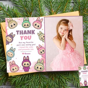 May include: A greeting card with a photo of a young girl in a pink dress and a "Thank You" message. The card features cartoon bunny characters and the text "But my favorite part was seeing you! I loved the cake and presents too."