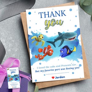 May include: Thank you card with a blue, yellow, and orange Finding Nemo character design. The text reads "Thank you. I loved the cake and presents too. But my favorite part was seeing you! Jordan."