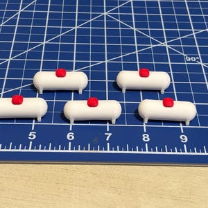 May include: Five white propane tanks with red caps. The tanks are arranged in a row on a blue grid surface.