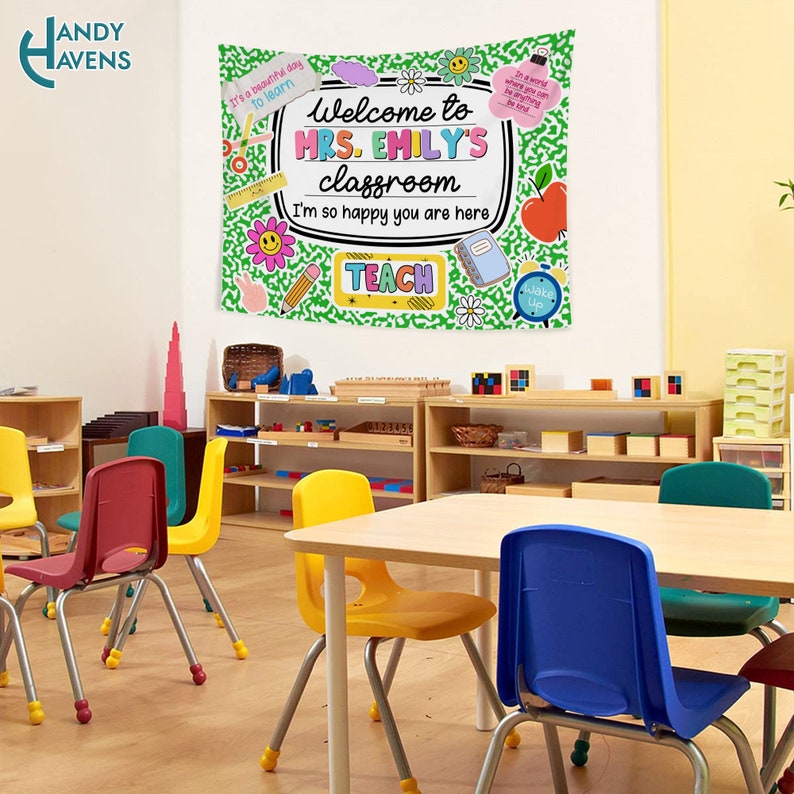 Puede incluir: Un aula decorada con una pancarta de bienvenida verde y blanca que dice "Bienvenido al aula de la Sra. Emily. Estoy muy contenta de que est&eacute;s aqu&iacute;." La pancarta tiene pegatinas e ilustraciones coloridas. El aula tiene una mesa con cuatro sillas, una estanter&iacute;a y una variedad de juguetes coloridos.