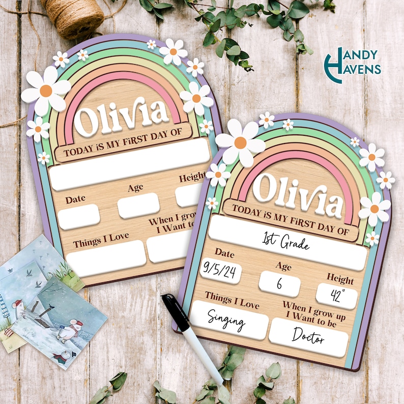 May include: A wooden sign with a rainbow and daisies design. The sign is personalized with the name "Olivia" and the text "Today is my first day of 1st Grade". The sign also includes sections for the date, age, height, things I love, and when I grow up I want to be.