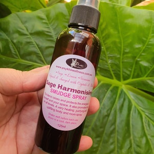 May include: A brown glass bottle with a black spray top and a white label. The label says "Sage Harmonising Smudge Spray" and includes the website address "www.psykhewellness.com.au". The bottle is 125ml.