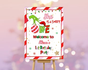 Könnte beinhalten: Festliches Geburtstagsplakat mit Grafiken und Text zum Thema Grinch. Auf dem Schild steht "She is a Sweet One" und "Welcome to Alison's 1st Birthday Party". Das Design umfasst eine Grinch-Hand, einen Weihnachtsmannhut und rote und grüne Akzente.