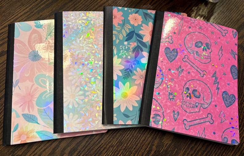 Pu&ograve; includere: Una collezione di cinque quaderni con vari design. Le copertine presentano motivi floreali, texture olografiche e un motivo a teschio rosa. Ogni quaderno ha un dorso nero e un design di copertina unico, offrendo una variet&agrave; di stili.
